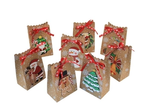 Detalle de bolsas de regalo de Navidad en papel kraft con copos de nieve y cintas rojas