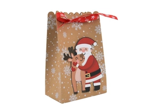 Detalle de bolsa de regalo de papel kraft marrón con copos blancos y lazo de seda rojo