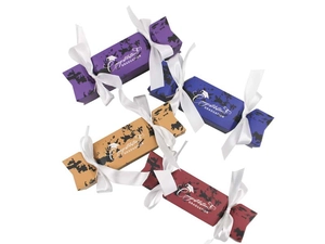 Close-up of four colorful graduation favor boxes in purple, blue, gold, and red with ribbons