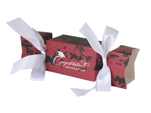 Macro shot of red graduation candy box with white ribbon and diploma graphic detail