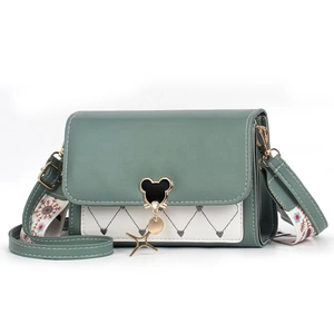 Detail of green and white patchwork bag featuring heart quilting and mouse metal buckle