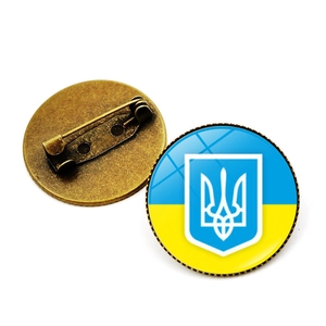 Détail macro de la broche blason Ukraine avec base métal et finition dôme verre