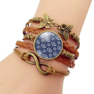 Detail of vintage layered leather evil eye bracelet with infinity and butterfly charms