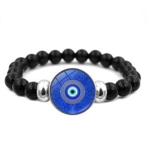 Makro-Detail des türkischen Evil-Eye-Charms auf Perlenarmband mit blauem Glas und Silber
