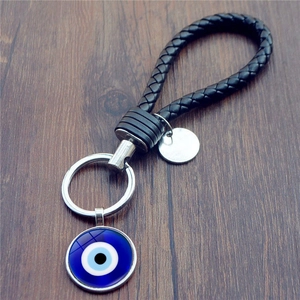 Portachiavi con occhio turco blu e corda in pelle nera intrecciata a mano e ciondolo