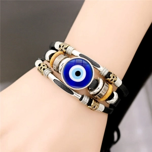 Detailed close-up of multilayer braided leather bracelet with blue Turkish Evil Eye charm