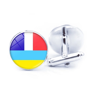 Close-up of silver-tone cufflinks featuring colorful flag patterns on white background