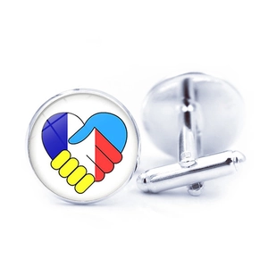 Detail of silver round cufflinks with heart handshake emblem and flag colors for men