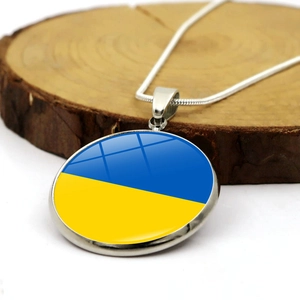 Detail of Ukraine flag necklace with blue and yellow stone on rustic wood background