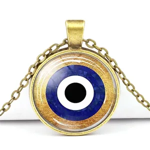 Vintage bronze Evil Eye necklace with blue glass crystal dome on white background