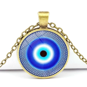 Macro detail of Evil Eye necklace featuring blue glass pendant and antique bronze chain