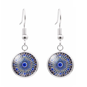 Vue macro de boucles d'oreilles œil bleu en verre avec crochets argentés sur fond blanc