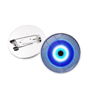 Detail of Turkish blue evil eye brooch set featuring silver metal back and safety pin