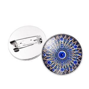 Detail of silver Turkish Evil Eye brooch showing safety pin back and mandala pattern front