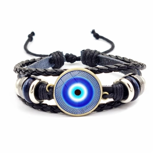 Macro shot of the handmade woven leather band and blue Evil Eye amulet detail