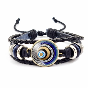 Detailed close-up of handmade braided leather bracelet with Turkish evil eye glass charm