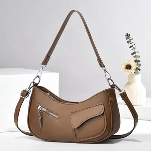 Detail of brown faux leather half-moon bag featuring a front zipper and silver hardware