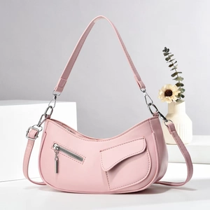 Pink crescent shoulder bag with silver zipper detail and wide strap on white minimalist stand