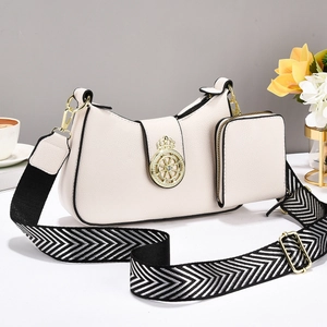 Elegante bolso bandolera de cuero crema con corona dorada y correa tejida ancha a la moda