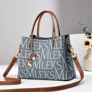 Graue Denim-Tragetasche mit weißem Schriftzug, braunem Leder und Meeres-Anhängern
