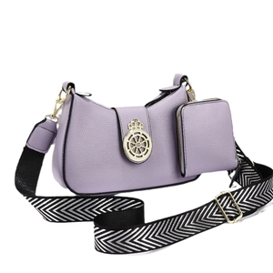 Bolso morado de cuero granulado con emblema dorado, correa tejida y estuche a juego