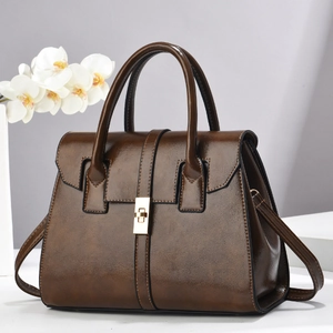 Gros plan d'un sac à main marron foncé vintage avec finition brillante et fermoir doré