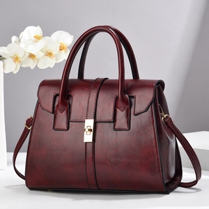 Sac à main élégant rouge foncé en cuir avec boucle dorée et doubles poignées en studio