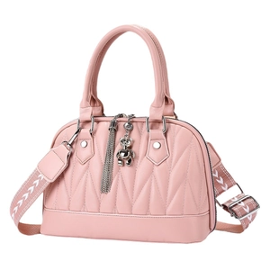 Quilted pastel pink Boston bag with metal bear charm and wide patterned shoulder strap