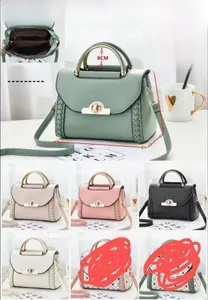 Détail macro du sac bandoulière patchwork macaron avec poignée métal et fermoir rotatif