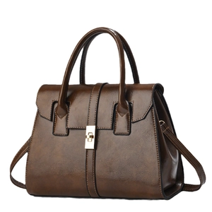 Sac à main marron foncé en cuir brillant avec fermoir doré et bandoulière amovible
