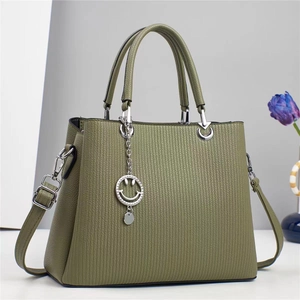 Detail of green striped leather handbag with silver charm and adjustable strap