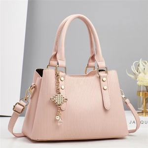 Sac à main rayé rose avec rivets dorés et élégant pendentif en perle sur le côté