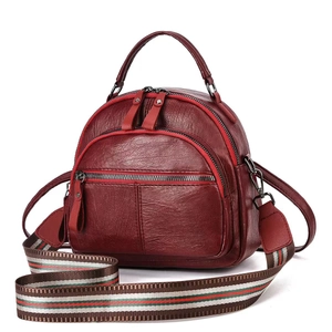 Detail of burgundy pebbled leather backpack with a colorful striped detachable strap