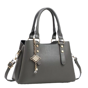 Sac à main gris rayé avec garniture dorée et pendentif élégant en perles
