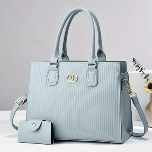 Light blue striped handbag set with gold hardware and matching card holder on white stand