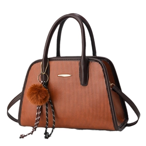 Brown striped leather handbag with plush ball charm and woven detail shown in front view