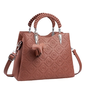 Bolso de mano marrón grabado de varias capas con asas trenzadas y colgante de elefante