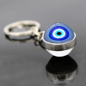 Dettaglio macro del portachiavi occhio turco con perla di vetro blu e montatura in argento