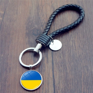 Dettaglio portachiavi in pelle intrecciata con ciondolo in vetro bandiera ucraina