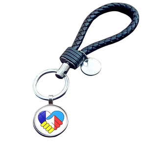 Portachiavi in pelle intrecciata con ciondolo a cuore blu e giallo con motivo stretta di mano