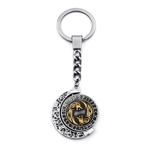 Vue détaillée du porte-clés viking rotatif avec des loups dorés et des runes gravées