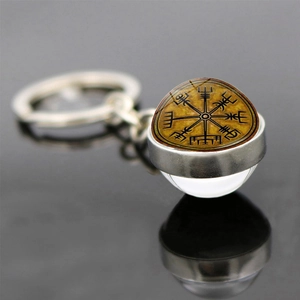 Vintage Viking Vegvisir compass keychain with glass cabochon on a black reflective surface
