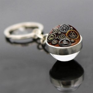 Macro shot of Viking Vegvisir compass and Valknut symbols inside a glass ball keychain