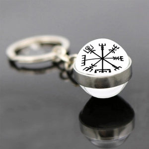 Macro shot of silver Viking Vegvisir compass glass ball keychain with reflection