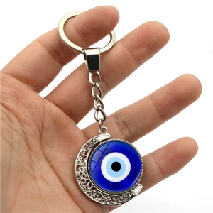 Llavero de ojo turco giratorio con marco de luna plateado calado y colgante de cristal