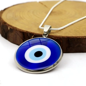 Primer plano del colgante de ojo turco de cristal con cadena de serpiente de plata