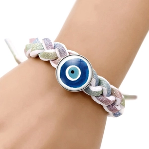 Close-up van handgemaakte driekleurige geweven armband met glazen Evil Eye bedeltje