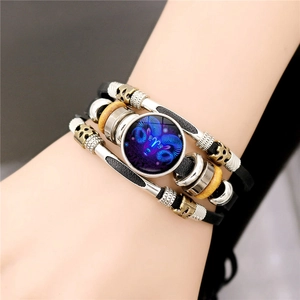 Detailed view of multilayer leather Aries bracelet with glowing zodiac glass charm