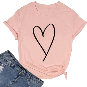 T-shirt rose en coton avec imprimé cœur et jean bleu délavé posés à plat sur fond blanc