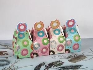 Close-up of donut-themed bakery boxes with creative handles and colorful prints